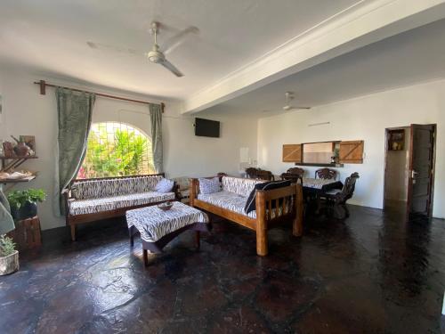 a living room with couches and a table and a window at Watamu House in Watamu