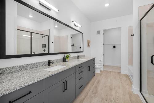 a bathroom with two sinks and a large mirror at Landing Apartments - Denton in Denton