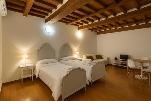 a bedroom with two beds and a table at appartamento Ferraresi in San Felice sul Panaro