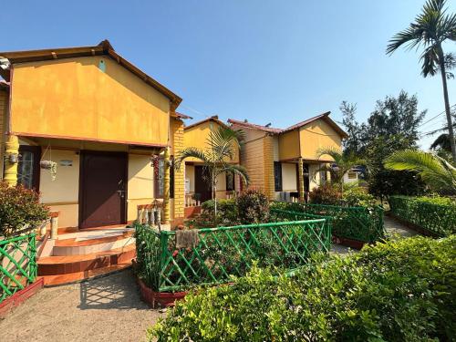 une maison avec une porte verte en face de celle-ci dans l'établissement Resort Green Earth, à Tajpur