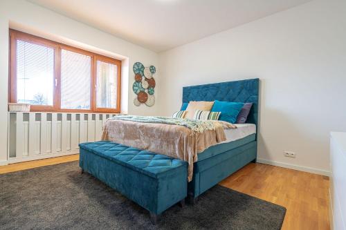 a bedroom with a blue bed and a window at B-Home Apartments in Trenčín