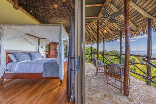 a bedroom with a bed and two chairs on a porch at TikiVibez in Coronado
