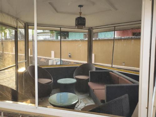 a room with chairs and a table and windows at TwinVilleCove, affordable villas located in Ajah in Obalende