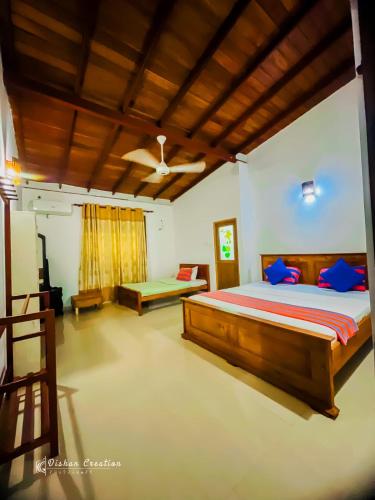 a bedroom with a large bed with blue pillows at Sajee Villa in Hikkaduwa