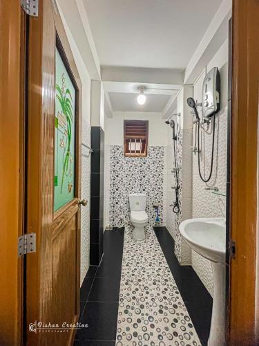 a bathroom with a toilet and a sink at Sajee Villa in Hikkaduwa