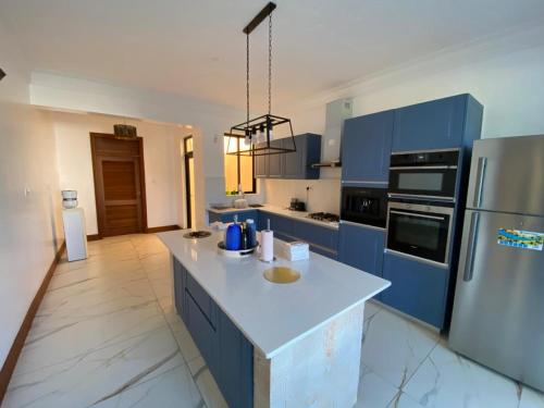 a kitchen with blue cabinets and a white counter top at Vipingo Luxury Villa in Kilifi