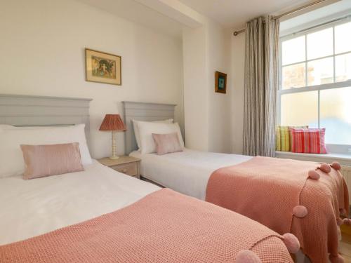 a bedroom with two beds and a window at Tradewinds in Newquay