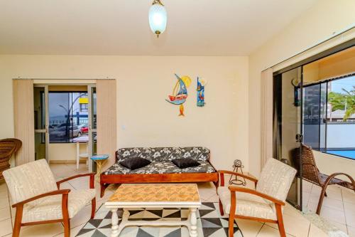 a living room with a couch and a table and chairs at Beira Mar e Frente Lagoa de Barra Velha 4 Quartos in Barra Velha