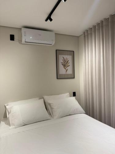 een slaapkamer met een bed met witte kussens bij You Smart Flats in Formosa