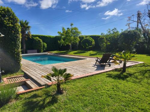un patio trasero con terraza de madera y piscina en Gîte du Ligal, en Najac