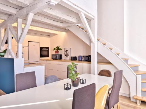 a dining room with a white table and chairs at Grand Verdière in La Rochelle
