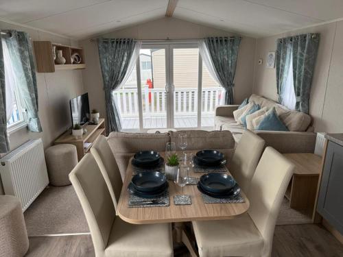 a living room with a table and chairs and a couch at Poppy Lodge LE 17 Ocean's Edge Park in Morecambe