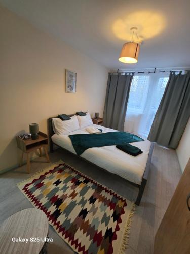 a bedroom with a large bed and a rug at Green & White Haven-Spacious 3BR in London