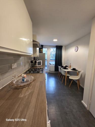 a kitchen with a table and a dining room at Green & White Haven-Spacious 3BR in London