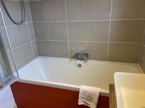 ein Badezimmer mit Badewanne und Dusche in der Unterkunft The Nuttings Cottage in Crail