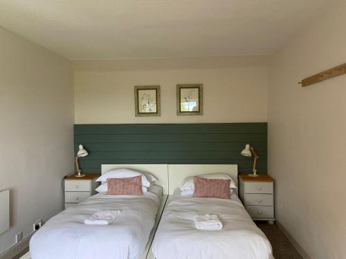 zwei Einzelbetten in einem Zimmer mit zwei Lampen in der Unterkunft The Nuttings Cottage in Crail