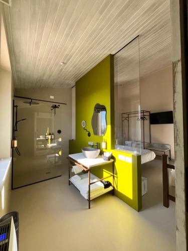a bathroom with a sink and a yellow wall at Agriboutique L'Uliveto Magico in Cannara