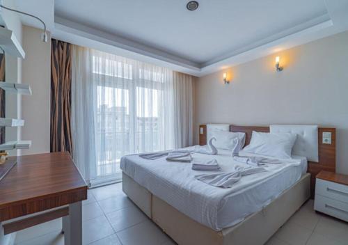 a bedroom with a bed and a desk and a window at Dora Thermal Tatil Köyü & Spa in İhsaniye