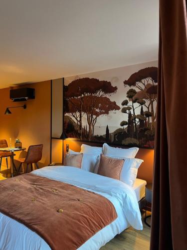 a bedroom with a large bed with a painting on the wall at Studios et Appartement meublé de tourisme in Altkirch