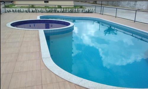 a swimming pool with blue water in a building at Lindo apartamento mobiliado in Ananindeua