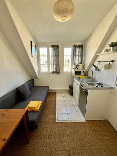 un piccolo soggiorno con divano e cucina di Studio Passy - Tour Eiffel a Parigi