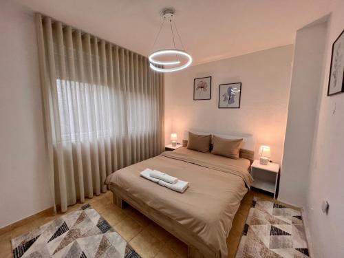 a bedroom with a bed with two white towels on it at Central DELUXE Apartment in Prilep