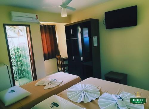 two beds with umbrellas on them in a room at Hotel Porto Real in Pôrto Real