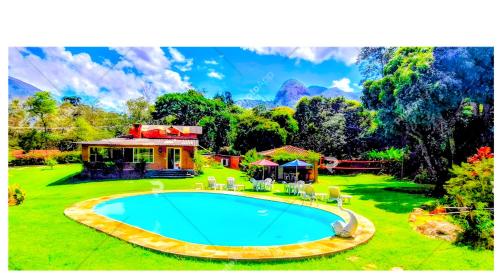 a house with a swimming pool in the yard at Pousada dos Chalés - Araras in Araras Petropolis