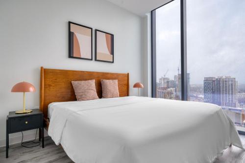 a bedroom with a white bed and a large window at Blueground Downtown Austin pool nr Texas State Capitol ATX-238 in Austin