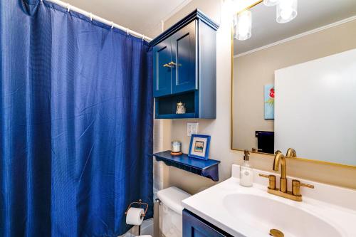 a bathroom with a sink and a blue shower curtain at Wilson Waterfront Getaway Near Hikes and Wineries! in Wilson