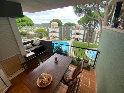 a balcony with a table and chairs and a pool at Apartamento Rocio en Calella in Calella de Palafrugell