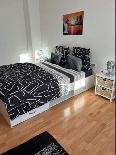 a bedroom with a bed with a black and white comforter at Aux Portes de Brisach in Sélestat