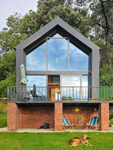 a house with a balcony and a dog laying in the grass at Green Hill in Batumi