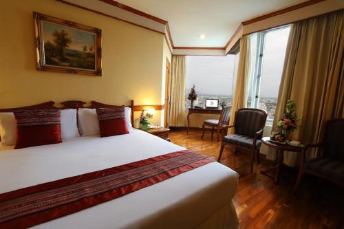 a hotel room with a bed and a large window at Duangtawan Hotel Chiang Mai in Chiang Mai