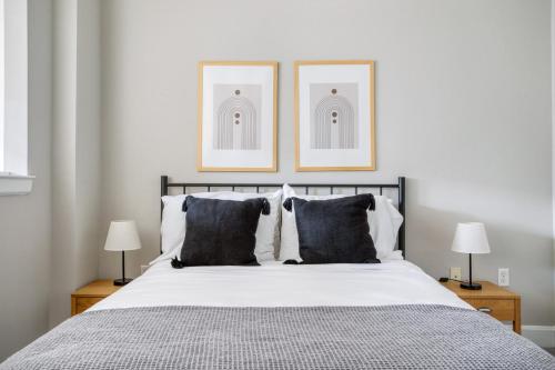 ein Schlafzimmer mit einem Bett mit zwei Bildern an der Wand in der Unterkunft Blueground Bethesda fitness center nr Cabin John Park WDC-666 in Bethesda