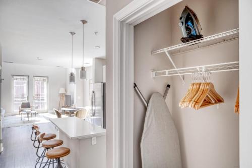 eine weiße Küche mit einer Theke und Stühlen in der Unterkunft Blueground Bethesda fitness center nr Cabin John Park WDC-666 in Bethesda