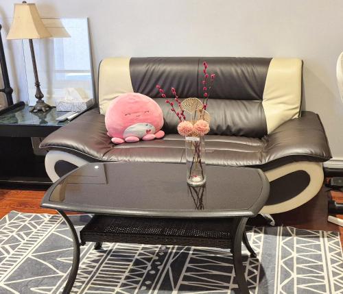 a pink stuffed animal sitting on a couch with a table at Toronto Spacious Cozy Mainfloor Room in Toronto