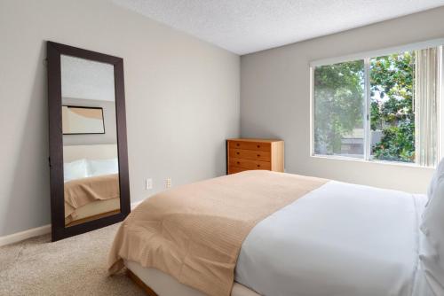 a bedroom with a large bed and a mirror at Blueground Campbell pool nr Campbell Park SFO-1998 in Campbell