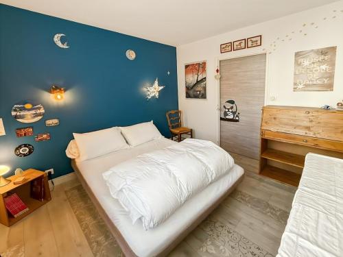 a bedroom with a large white bed and a piano at Appartement 95m2, Cœur d'Aurillac, Jusqu'à 5 pers in Aurillac