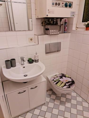 ein weißes Badezimmer mit Waschbecken und Toilette in der Unterkunft Citystudio Neuwied mit Schlafgalerie bis 5 Gäste direkt am Luisenplatz in Neuwied