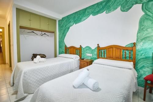 ロンダにあるオテル ビルゲン デ ロス レイエスの白いシーツが敷かれたベッドが2つある寝室