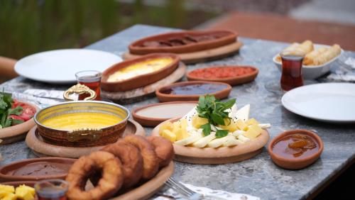 een tafel met verschillende soorten levensmiddelen op borden bij Melekona House in Kartepe