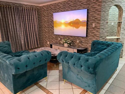 een woonkamer met twee blauwe stoelen en een tafel bij Tranquil Retreat in Durban