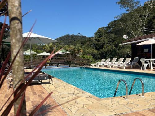 una piscina con sillas y sombrillas en un resort en Estação Serramar, en Lumiar