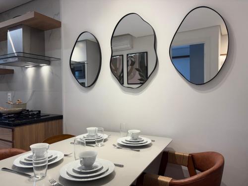 a table with plates and mirrors on the wall at Tupis Flats 1401 in Belo Horizonte