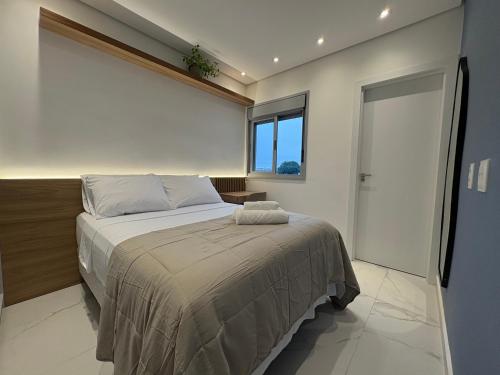 a bedroom with a large bed with a window at Tupis Flats 1401 in Belo Horizonte