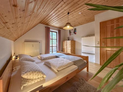 a bedroom with a large bed with a wooden ceiling at Weiherblasch in Dietersdorf