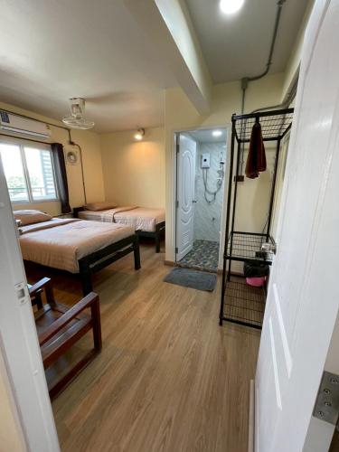 a small room with two beds and a mirror at Banhor Residence in Chiang Mai