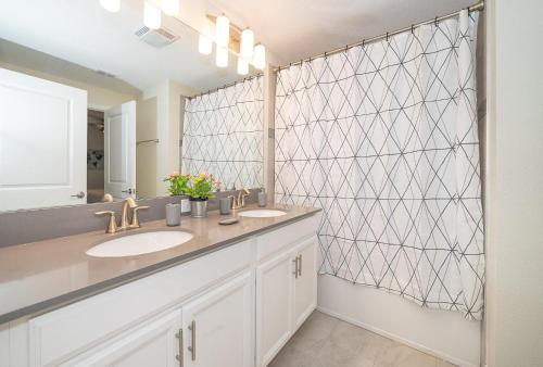a bathroom with two sinks and a large mirror at 4830FA TOWNHOUSE 4 BEDROOMS & 3 BATHROOMS + POOL in Kissimmee