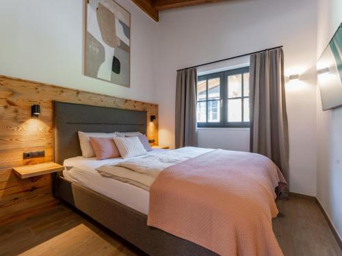 um quarto com uma cama grande e uma janela em Tauernlodge Eben D4 em Gasthof